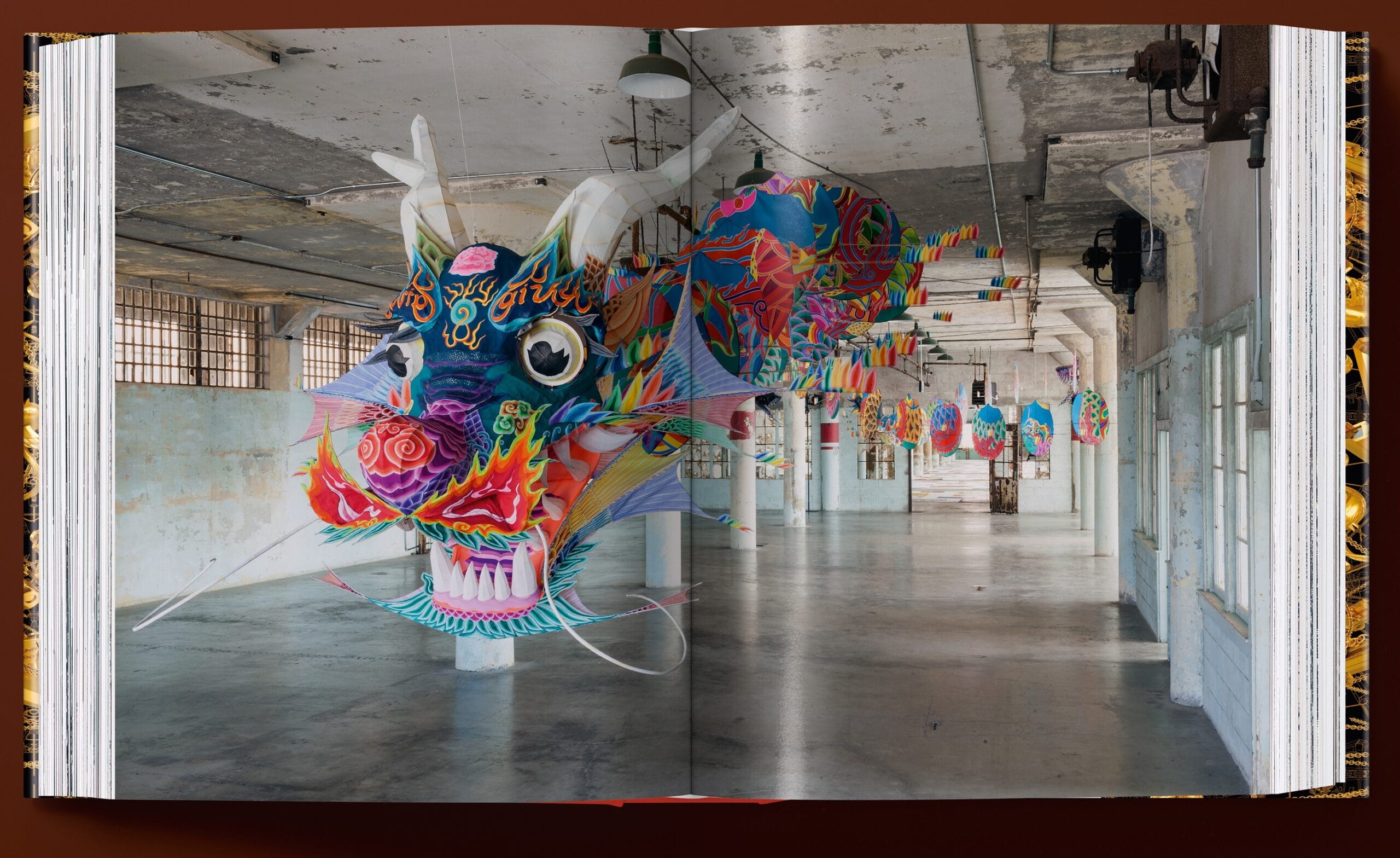 A spread from the book 'Ai Weiwei. Updated Edition' featuring an installation of a Chinese dragon inside of an exhibition space