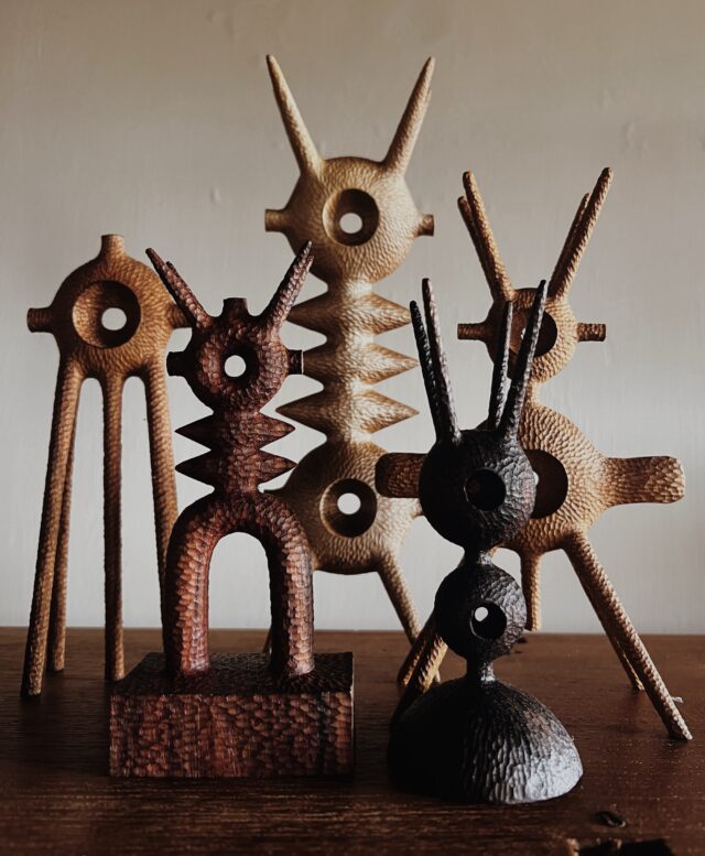 a collection of small, abstract, spindly wooden sculptures