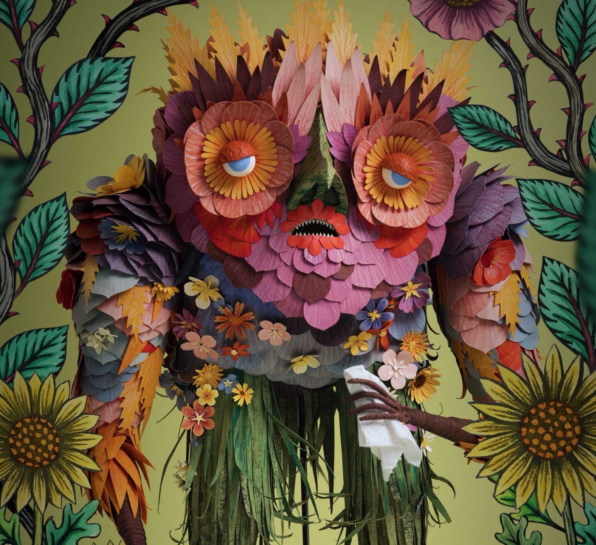 An elaborate paper puppet by Cat Johnston featuring floral and leafy elements with a sad expression