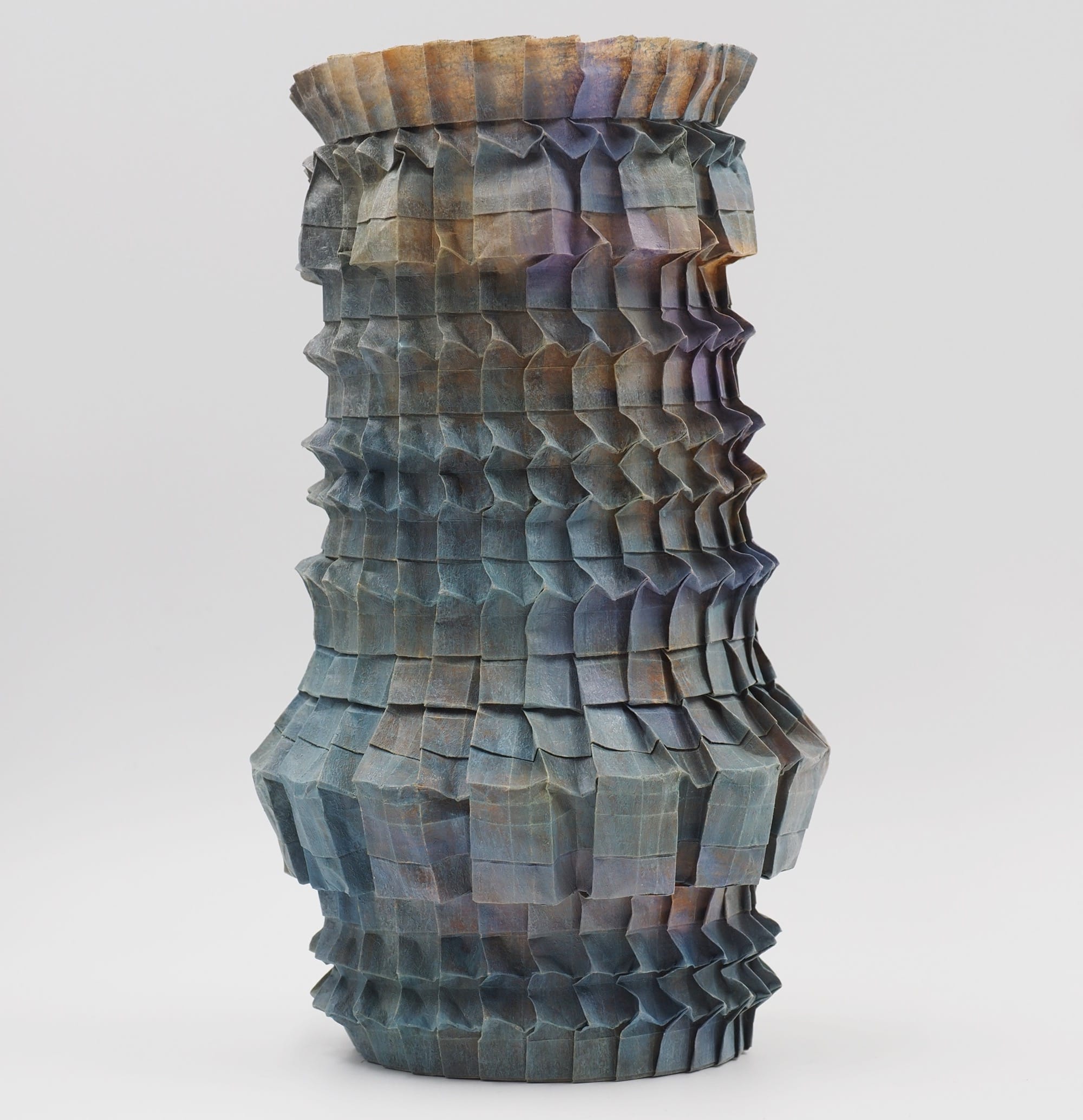 An origami paper vase with a nuanced gradient of grays and pinks