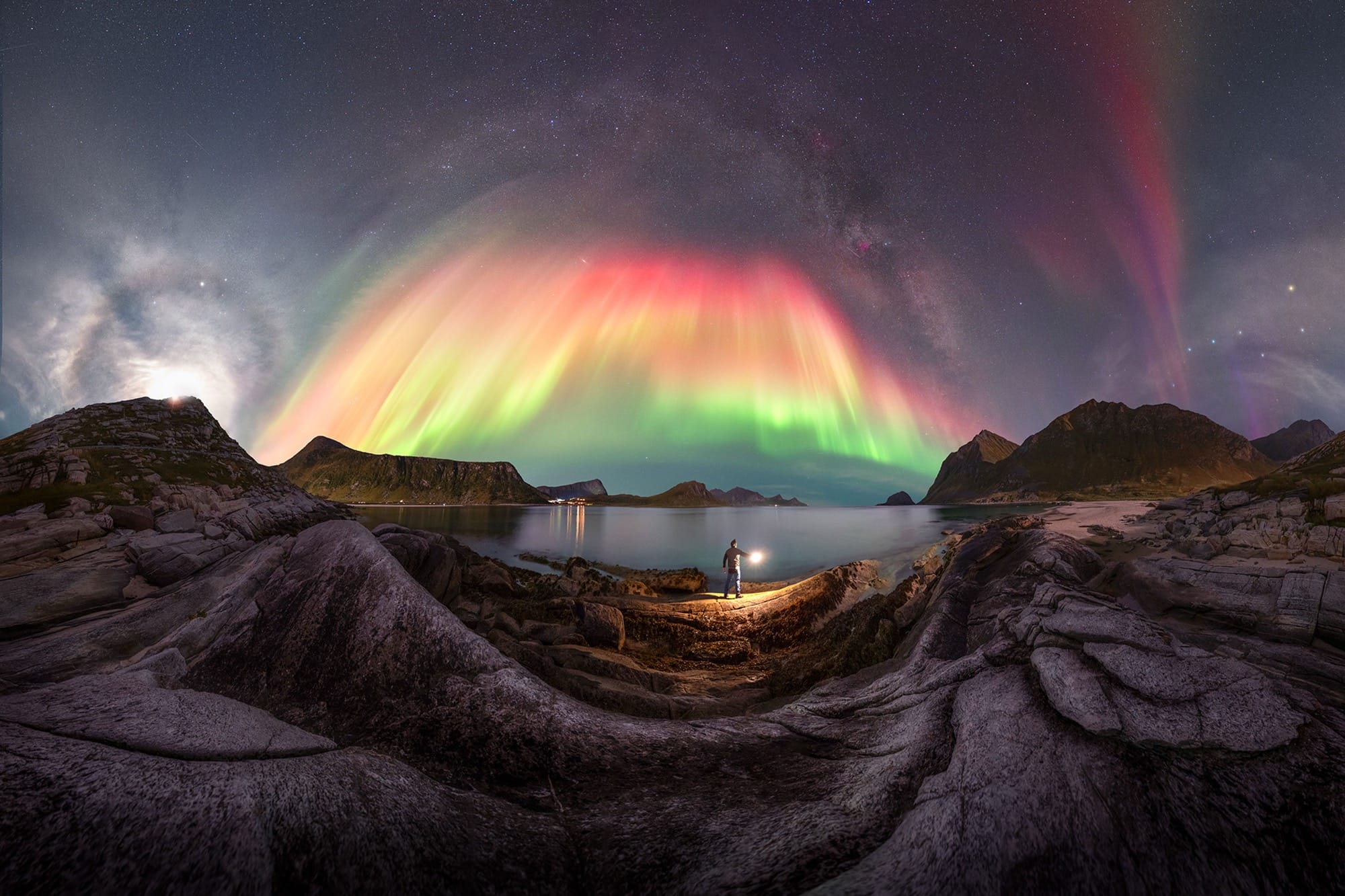 A colorful aurora borealis captured over a rocky landscape