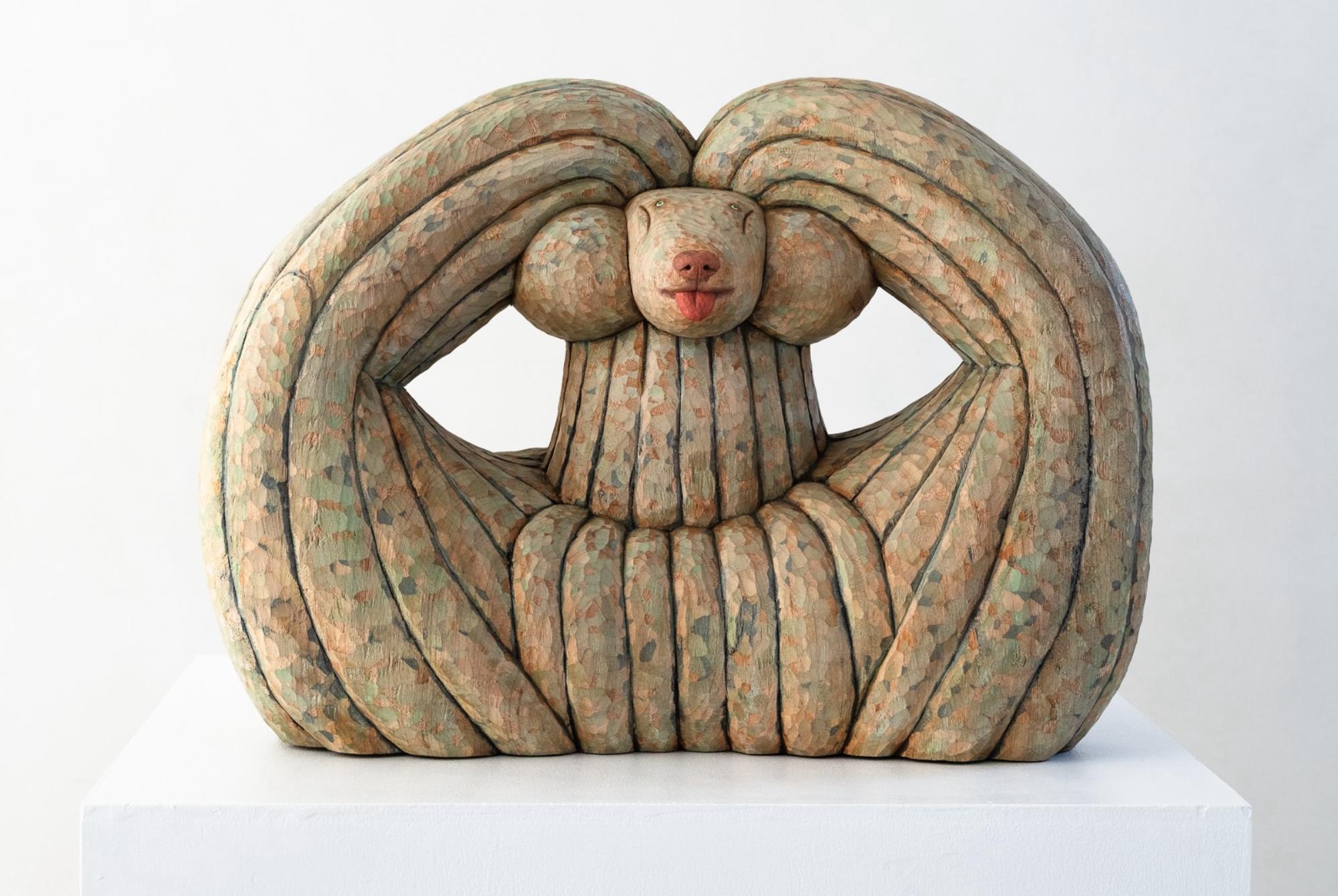 a wood-carved sculpture of a dog by Misato Sano