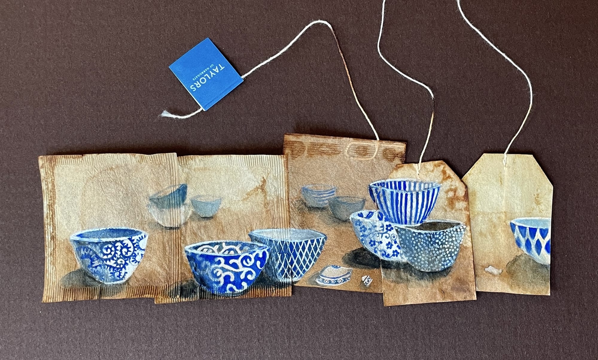 A small painting of blue-and-white patterned bowls by Ruby Silvious on a series of conjoined teabags