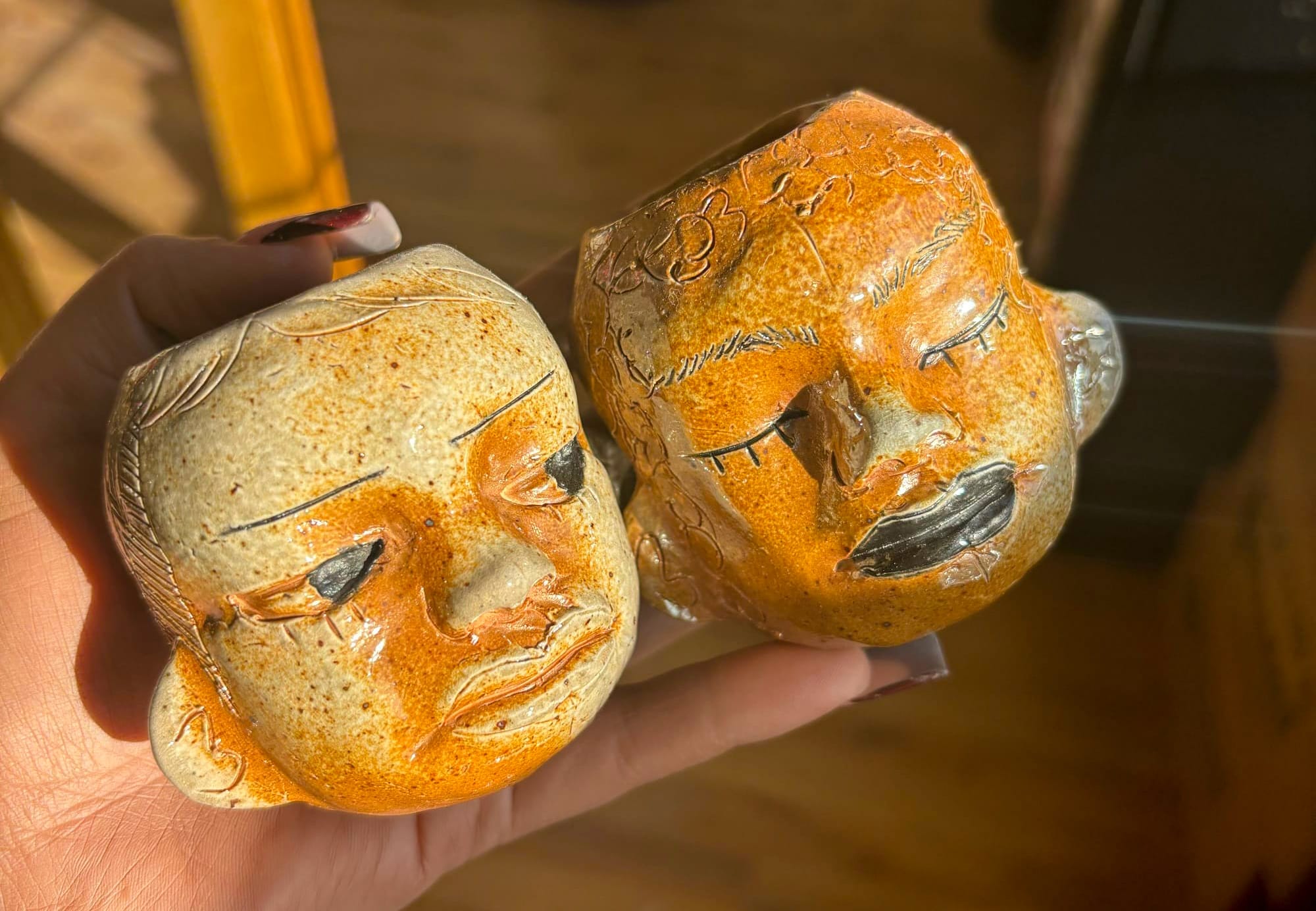 a hand holding two small head pots