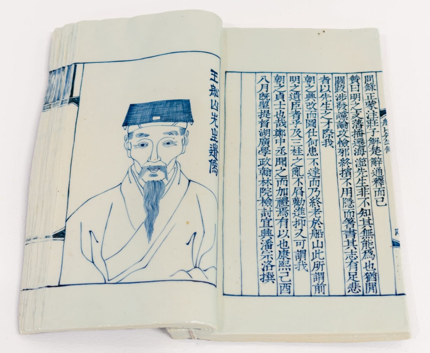 an open porcelain book that appears weathered with an illustrated figure on the left and text on the right